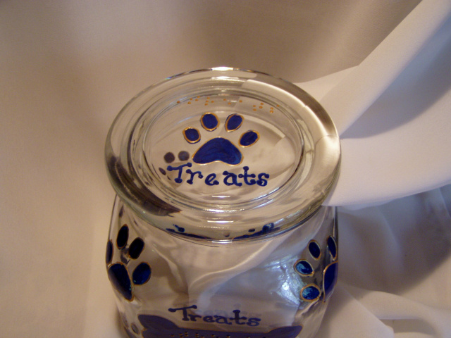 Jars are glass, square 1qt. size, with plastic seal on inside of lid to ensure freshness. The lid has a pawprint and the word "treats" in raised dot braille above the pawprint, and in script below the pawprint.  The pawprint design is outlined so the design can be felt all the way around the jar.  The front of the jar has a dog bone shape (also outlined) with the word "Treats" in raised dot braille.